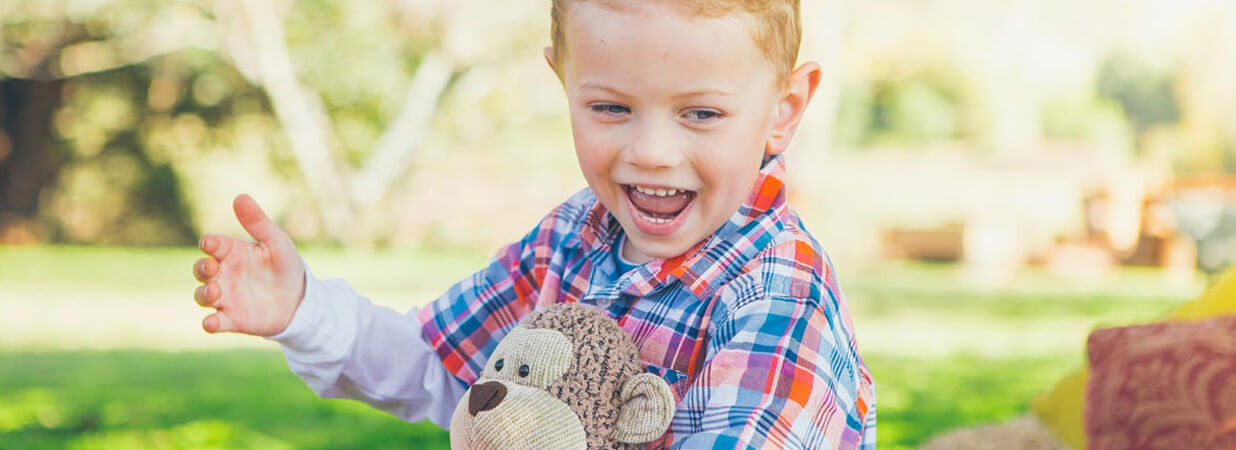 Kid Smiling with Teddy Bear